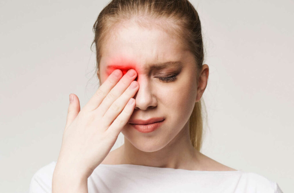 A woman rubbing her eyes as she suffers from severe burn in her eyes.