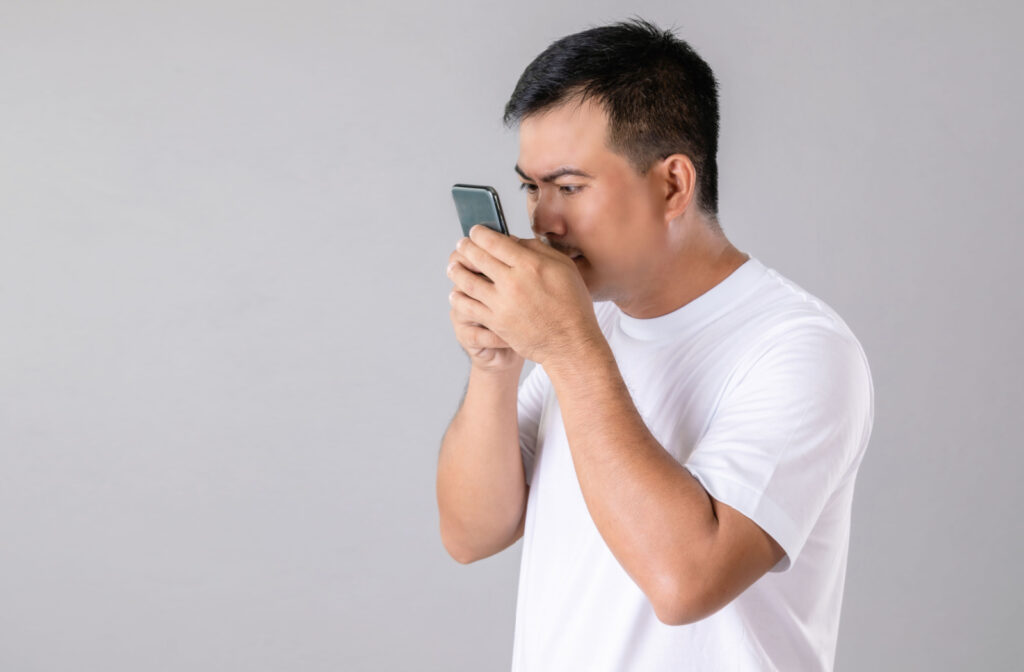 A man holding his smartphone very close to his face