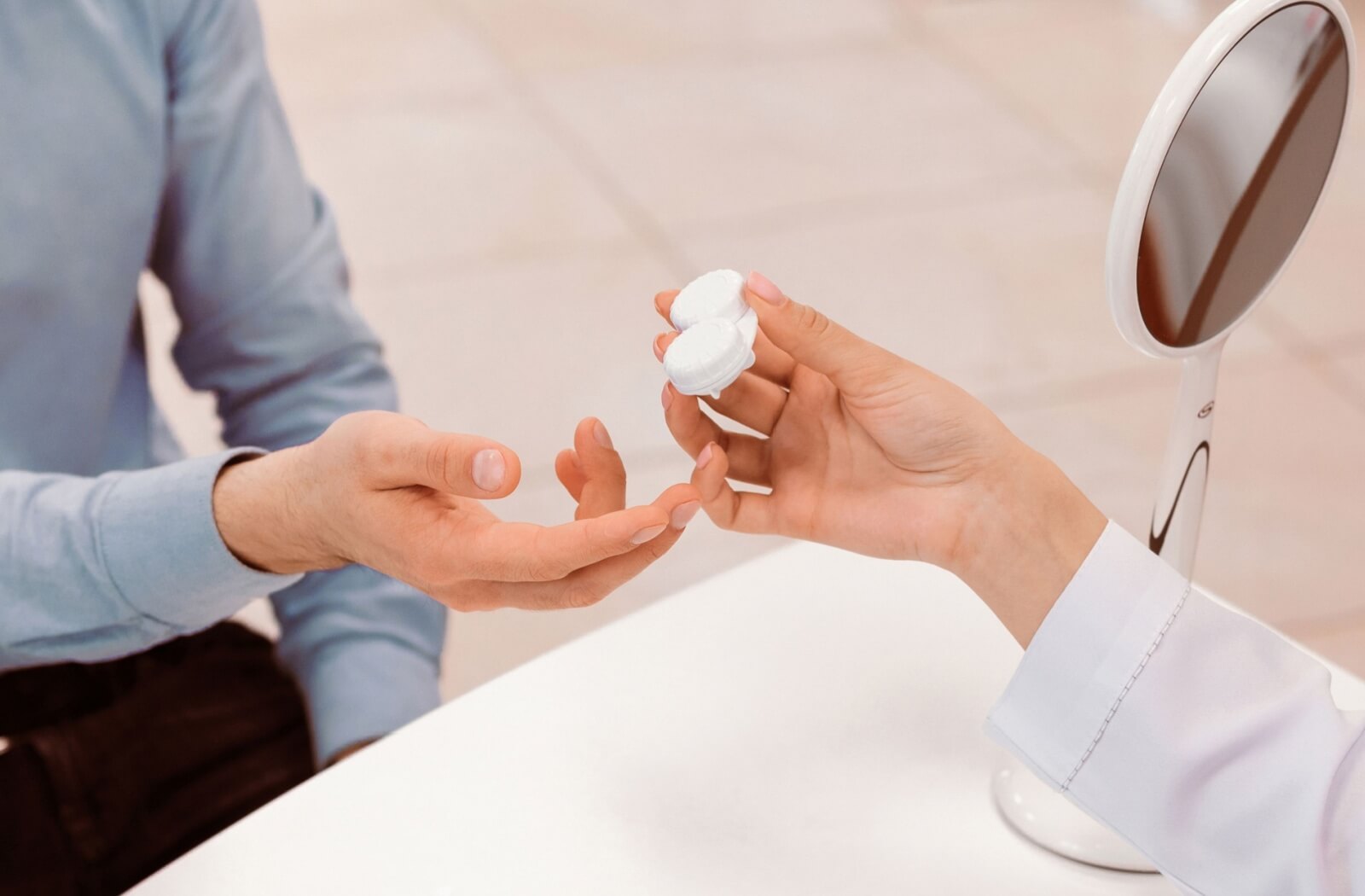A person receives a case with their contact lenses from an optician.